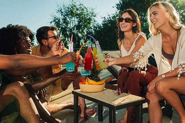 istock Friends toasting colorful drinks at a summer pool party 2206139082