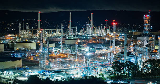 Aerial shot of a chemical plant on the shores of San Francisco Bay in Martinez, California brightly illuminated by floodlights on a dark night.