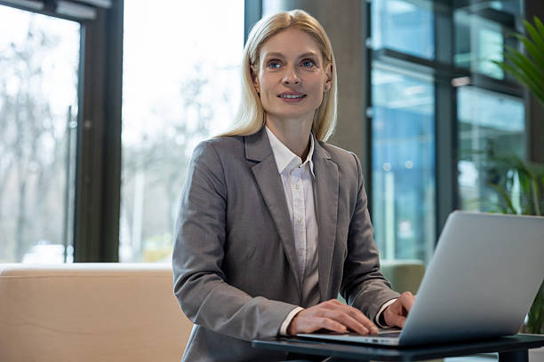 istock Female entrepreneur sitting on sofa working on laptop in office 2206139768