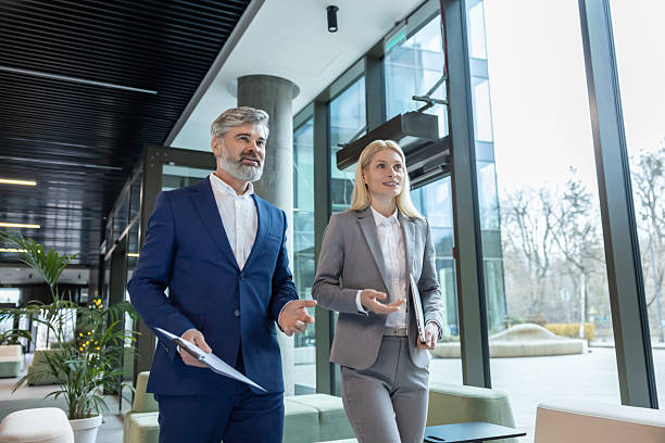 istock Businesspeople wearing suits walking together smiling while talking about company projects 2206139802