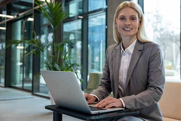istock Businesswoman sitting on sofa typing on laptop while working online in office 2206139818