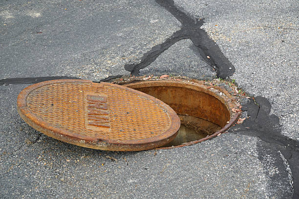 istock close up on opened rustic manhole cover on the street 2206155329