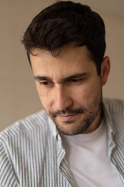istock Close-up portrait of a thoughtful man with a serious expression, looking downwards in contemplation 2206157679