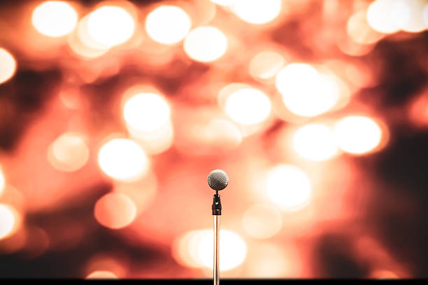 Microphone Public speaking backgrounds, Close-up the microphone on stand for speaker speech presentation stage performance with blur and bokeh light background.