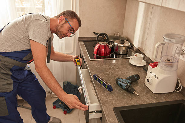 istock Handyman fixing kitchen cabinets in the apartment. 2206165338