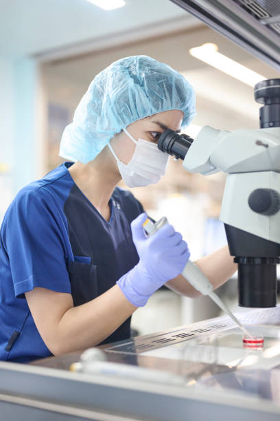 Embryologist using a microscope in the culture room