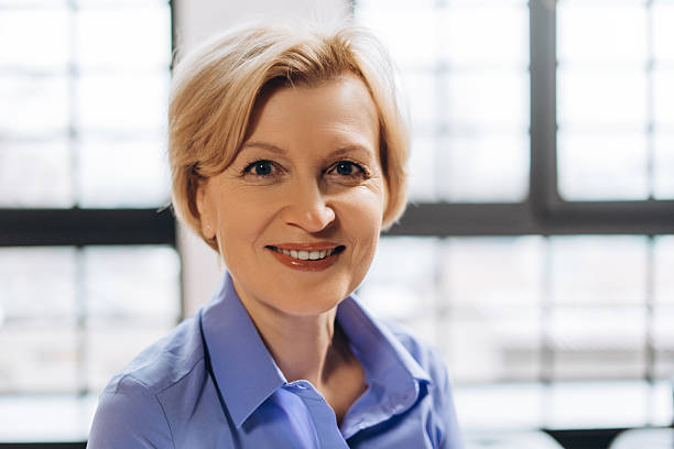 istock Positive middle aged female looking at camera while posing in the office 2206169278