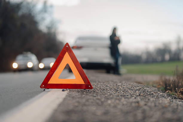 istock Warning triangle sign placed on road by driver after car breakdown on country road 2206169973