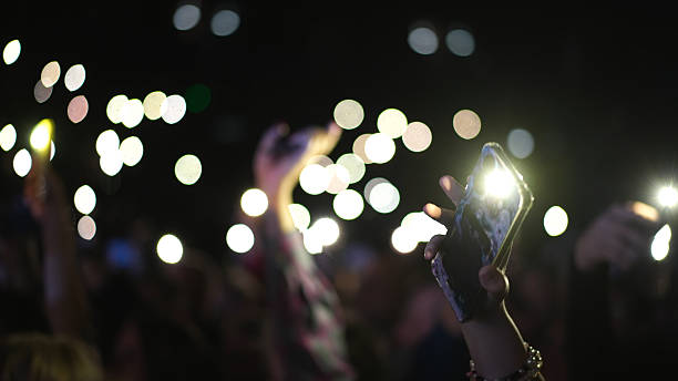istock Music performance people wave phone flash lights. Flashlights concert atmosphere 2206171033