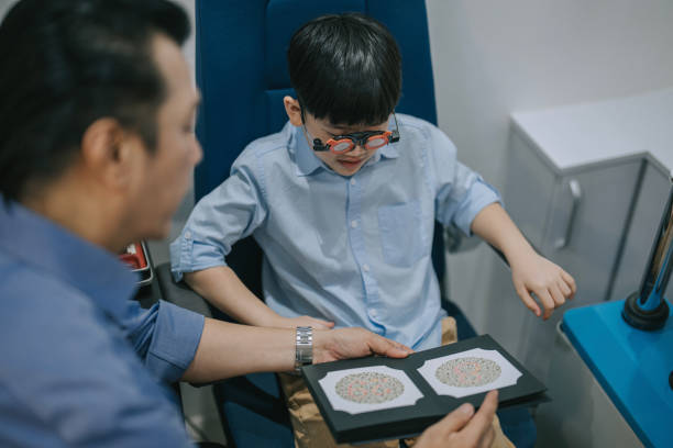 Asian optometrist doing color blind eye test with a boy in clinic