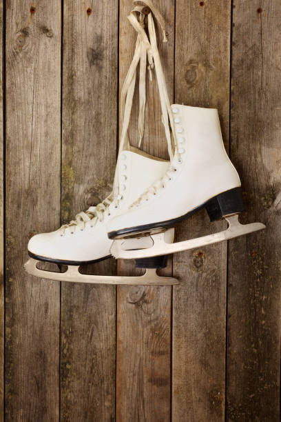 istock Old ice skates hanging from laces on wooden wall 2206175464
