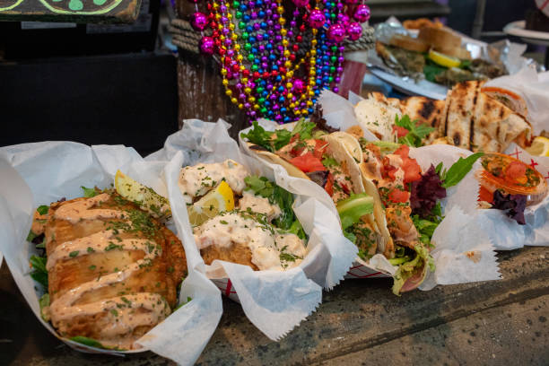 Cajun food on a wooden table surrounded by Mardi Gras beads.
