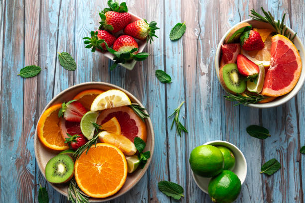 istock Slices of limes, oranges, grapefruit and strawberries arranged in bowls on a rustic blue background. Vibrant and refreshing image. 2206179952