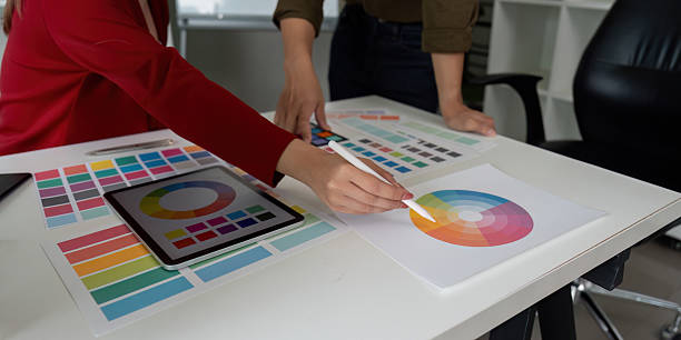 istock Color Theory and Teamwork. Designers discussing color theory while working on digital and printed palettes. 2206180559