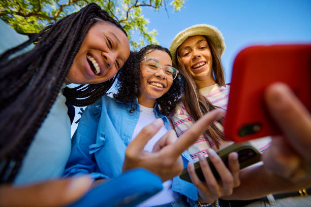 istock Three Gen Z students looking at their smartphones and laughing together 2206183767