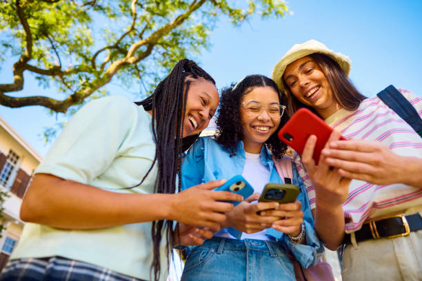 istock Three Gen Z students looking at their smartphones and laughing together 2206183778