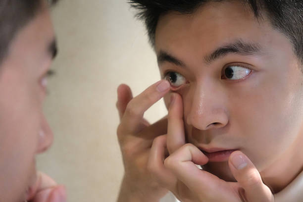 istock Asian young man wearing contact lenses in mirror 2206184068