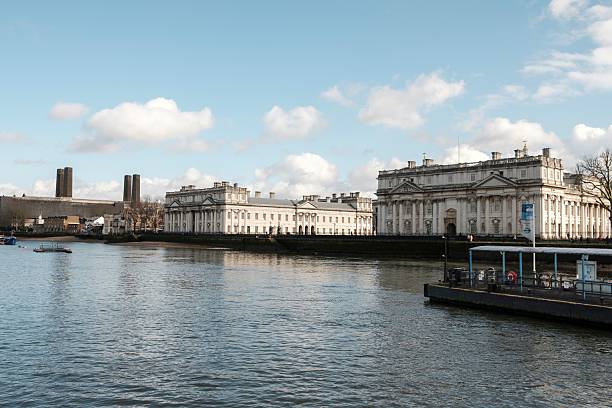 London, United Kingdom – February 24, 2025: View of historic buildings along the River Thames in London under a blue sky, showcasing classic architecture.