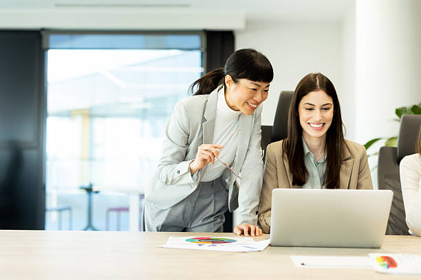 istock Two colleagues sharing a light moment in a modern office environment during a productive day 2206185989