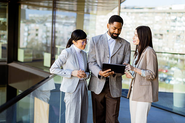 istock Group of professionals collaborates on a tablet in a modern office setting during daylight 2206186005