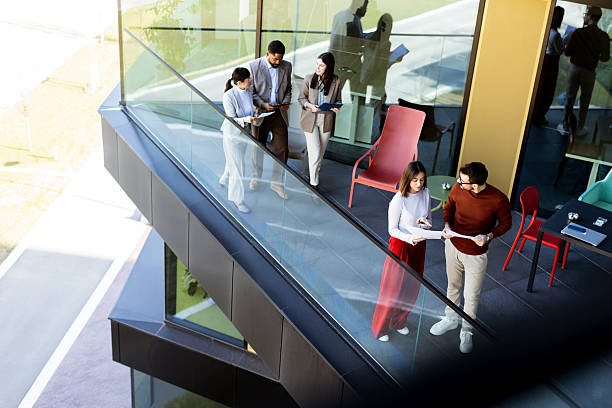 istock Group of professionals collaborating on project details in modern office space during sunny day 2206186044