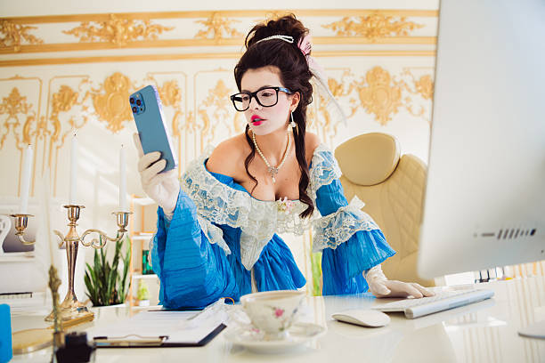 istock Elegant Woman in Historical Costume Using Smartphone in Modern Office Interior, Blending History and Contemporary Technology 2206187952