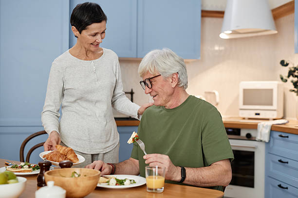 istock Smiling Elderly Couple Having Breakfast in Kitchen 2206189649