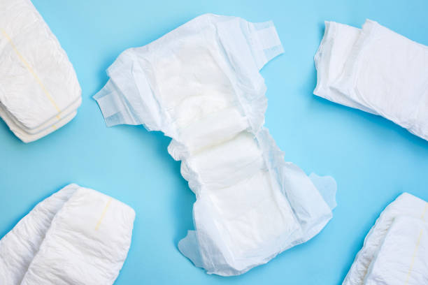 istock Many white diapers on light blue table background. Top view. 2206190240