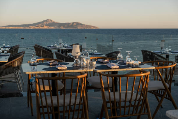 istock Breathtaking seaside dining setup with neatly arranged tables, shimmering glassw 2206190545