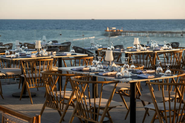 Stunning oceanfront dining scene with elegantly set tables and glassware