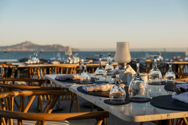 istock Perfectly arranged restaurant tables by the ocean, with fine glassware 2206191000