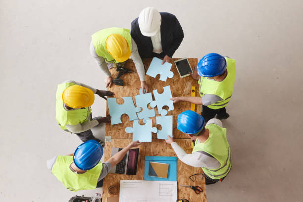 istock Above view of architect and manual workers joining puzzles at construction site. 2206191818