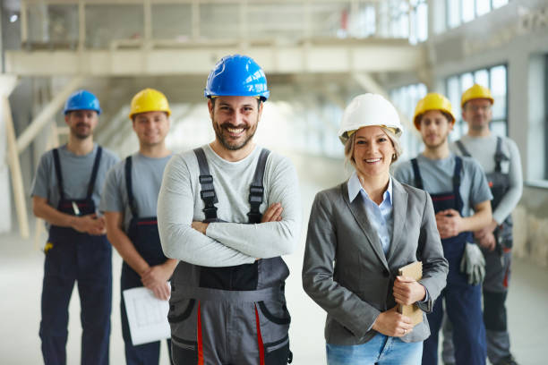 istock Happy worker and female architect in front of their colleagues at construction site. 2206192959