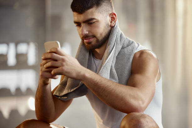 istock Young male athlete using smart phone on break in a gym. 2206194066