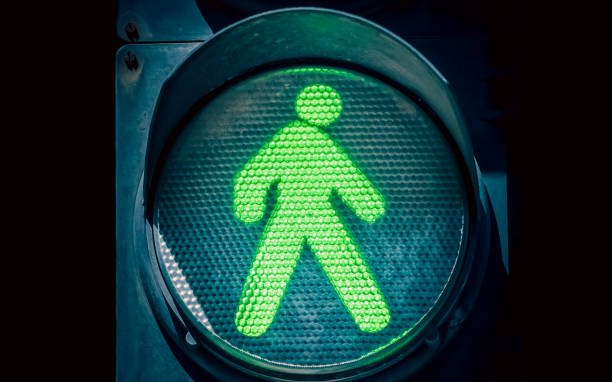 istock traffic light with a green man on a black background 2206198516
