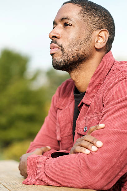 istock Pensive man sitting at table contemplating in nature 2206199066