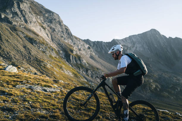 istock Mountain biker rides trail in mountain meadow at sunset 2206199874