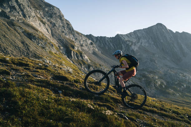 istock Mountain biker rides trail in mountain meadow at sunset 2206199902