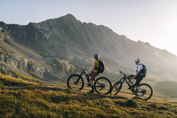 istock Mountain bikers pause in mountain meadow 2206199910
