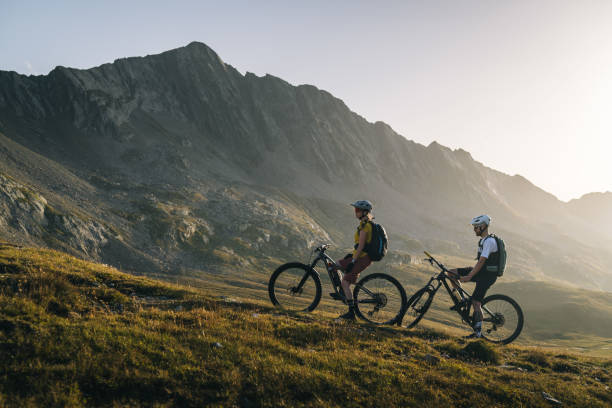 istock Mountain bikers pause in mountain meadow 2206199923