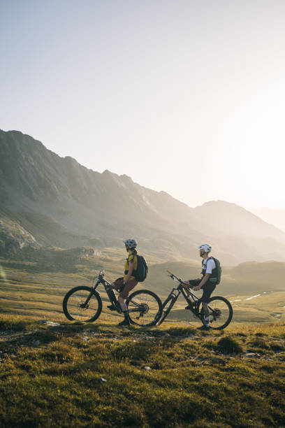 istock Mountain bikers pause in mountain meadow 2206199932