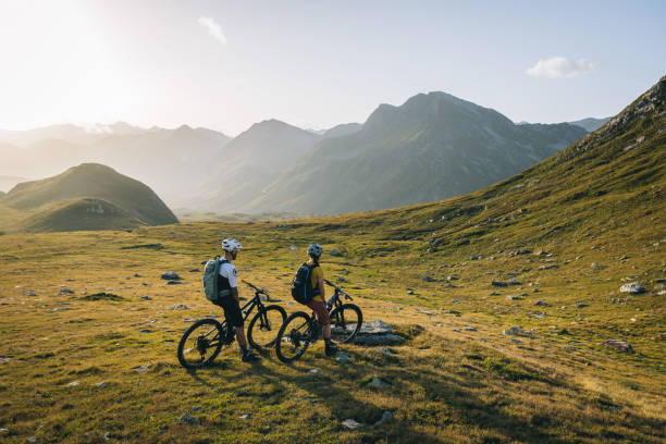 istock Mountain bikers pause in mountain meadow 2206199952