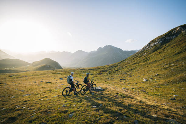 istock Mountain bikers pause in mountain meadow 2206199962