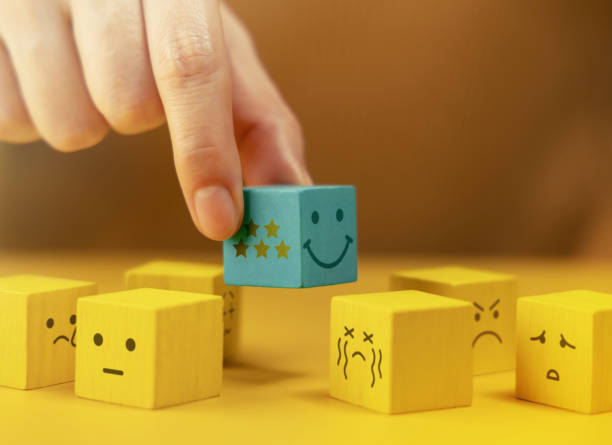 istock Customer Experiences Concept. Hand Picking a Five Star Review. a Smiling Happy Cube Stand Out among many Negative Feedback 2206200808