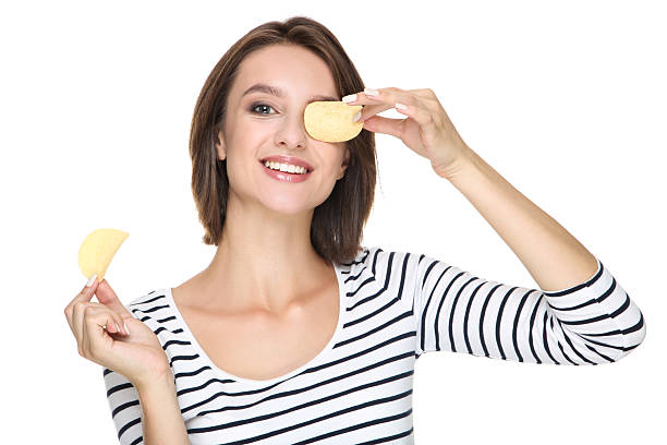 istock Young woman holding potato chips isolated on white background 2206206098
