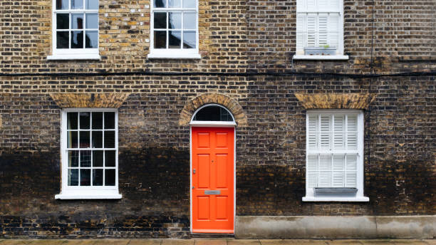 istock Red door and white windows on brick facade in london 2206207946