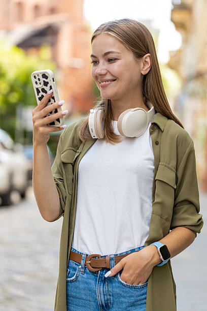 istock Beautiful young woman using smartphone typing text messages thinking and browsing internet on street 2206218895