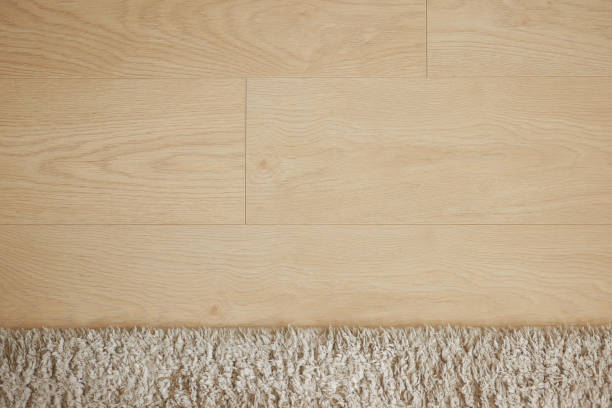 istock Light Wooden Floor with a Soft Textured Carpet Edge Enhancing Comfort 2206219601