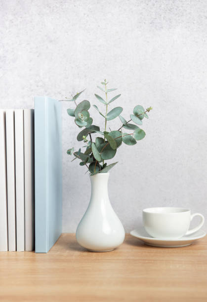 istock Eucalyptus branches, books, and coffee cup creating a cozy atmosphere on wooden desk 2206224003