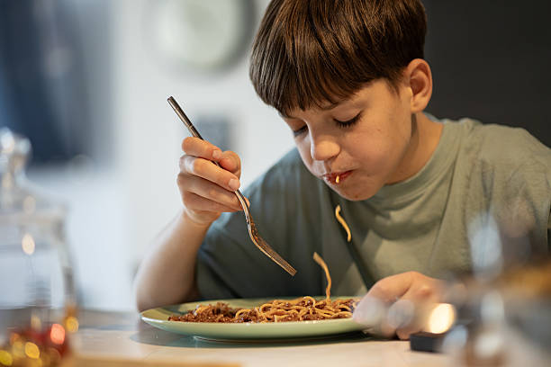 istock Happy Boy Enjoying Spaghetti Meal 2206224304
